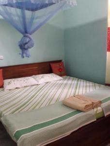 a bedroom with a bed with a blue wall at Himasha Guest in Mirissa