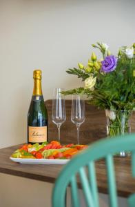 einen Tisch mit einer Flasche Wein und einem Teller Essen in der Unterkunft Santa Christina in Świeradów-Zdrój