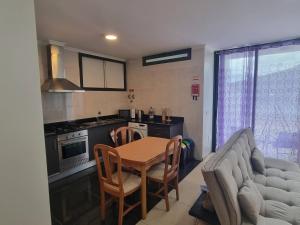 a kitchen and dining room with a table and a couch at Apto Vista Baía Machico in Machico