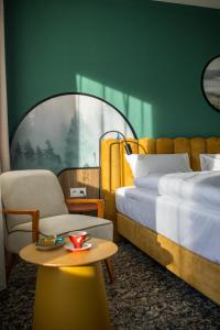 ein Schlafzimmer mit einem Bett, einem Stuhl und einem Tisch in der Unterkunft Santa Christina in Świeradów-Zdrój