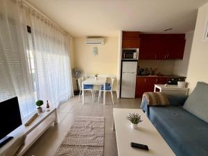 a living room with a blue couch and a kitchen at Estartit Jardins del mar 51 in L'Estartit