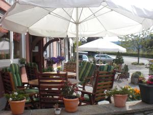 an outdoor cafe with chairs and tables and umbrellas at Alb Hotel Schalksburg in Albstadt