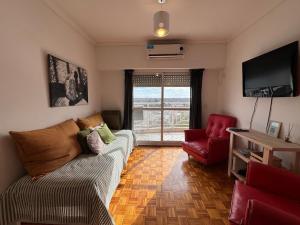 a living room with a couch and a red chair at Tigre Centro A - piscina y seguridad 24hs - Opcional cochera paga in Tigre