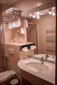 a bathroom with a sink and a toilet and a mirror at Hotel Bela Krajina in Metlika