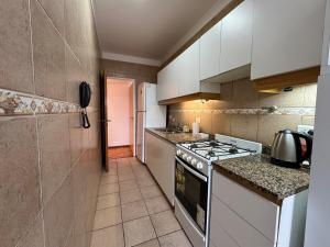 a kitchen with white cabinets and a stove top oven at Tigre Centro A - piscina y seguridad 24hs - Opcional cochera paga in Tigre