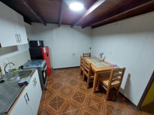 a kitchen with a table and a stove and a sink at Departamento Interior 3 Villarica Centrico in Villarrica