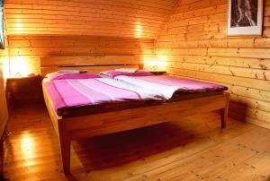 eine Holzhütte mit einem Bett in einem Zimmer in der Unterkunft Feriendorf Blauvogel Blauvogel 052 in Hasselfelde