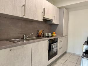 a kitchen with white cabinets and a sink at Monteurwohnung Peenstuuv in Demmin