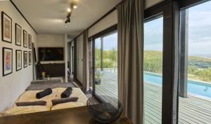 a bedroom with a bed and a balcony with a pool at Ateliéry Nad Závozom in Hrušov