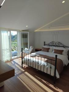 Orion Palace Boutique Hotel في دوريس: غرفة نوم مع سرير كبير وشرفة