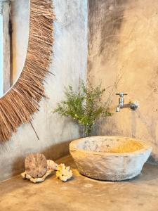 a bathroom with a stone sink and a mirror at Kokar Casa Hotel - Santo André in Santa Cruz Cabrália