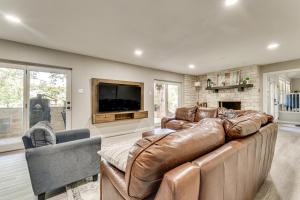 ein Wohnzimmer mit Ledercouch und Fernseher in der Unterkunft Home Gym, Office and Dock! Seguin Riverfront Retreat in Seguin