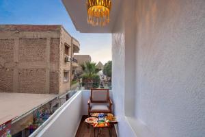 een balkon met een tafel en stoelen en een kroonluchter bij Pyramids Vision Hotel in Caïro