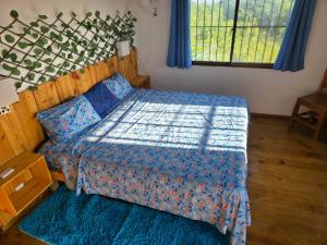 Casa vista hermosa في Camú: غرفة نوم بها سرير مع لحاف أزرق +34 صورة