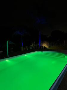 een fluorescerend groen zwembad 's nachts met bij Sitio Belo Vale in Juiz de Fora