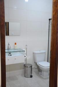 een witte badkamer met een toilet en een wastafel bij Sitio Belo Vale in Juiz de Fora
