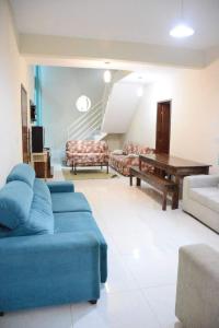 een woonkamer met een blauwe bank en een tafel bij Sitio Belo Vale in Juiz de Fora