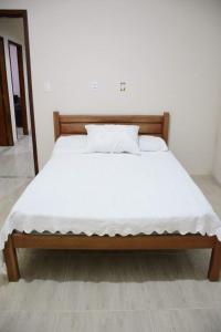 een bed met witte lakens en kussens erop bij Sitio Belo Vale in Juiz de Fora +27 foto's