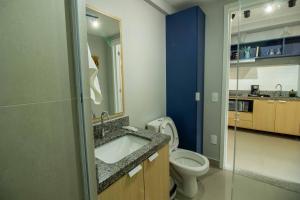 Un baño con inodoro, lavabo y espejo. en Novo studio sofisticado ao lado do Allianz Parque, en São Paulo 53 fotos más