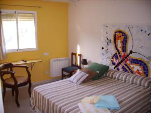 a bedroom with a bed and a desk and a window at Ca les Barberes in Paúls