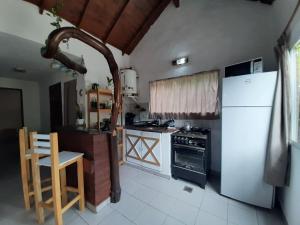 a kitchen with a white refrigerator and a stove at Buenas Ondas in Mar Azul +2 photos