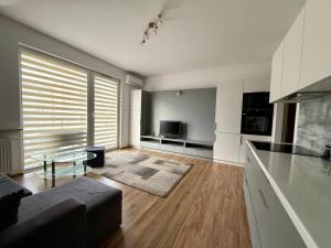 una sala de estar con un sofá y una mesa en Modlinska Residence by JumpInHere, en Nowy Dwór Mazowiecki