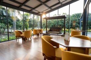 a restaurant with yellow chairs and tables and a piano at Wyndham Garden Jim Corbett Chhoi in Belparāo