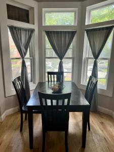a dining room with a table and chairs and windows at Jungle House Columbus Downtown Free Parking Sleeps 8 - Near Convention Center & Nationwide Arena - 2BR Short North Luxury Home - Over 5,800 Five Star Stays in Columbus