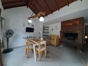 a living room with a table and a fireplace at Buenas Ondas in Mar Azul