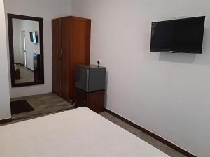 a room with a tv and a bed and a mirror at Coastal Residence in Hikkaduwa