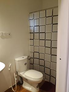 a white toilet in a bathroom with a tile wall at Coastal Residence in Hikkaduwa +18 photos