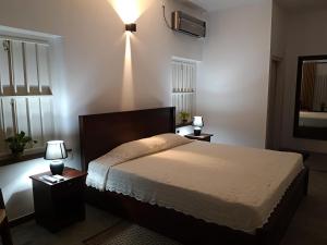 a bedroom with a bed with two night stands and two lamps at Coastal Residence in Hikkaduwa