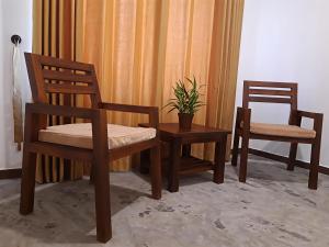 two chairs and a table with a potted plant at Coastal Residence in Hikkaduwa