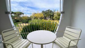 a white table and two chairs on a balcony at Écume et Sérénité Parking Privé Wifi Clim et LIT en 140 in La Grande-Motte