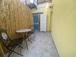 a patio with a table and chairs and a refrigerator at יחידת אירוח רחוב נחשון in Kibbutz Nachshon