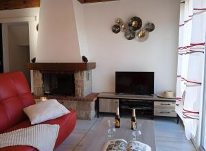 ein Wohnzimmer mit einem roten Sofa und einem Kamin in der Unterkunft Gîte Le Campet in Millau