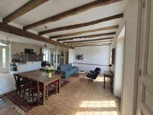 ein Wohnzimmer mit einem Tisch und einem blauen Sofa in der Unterkunft Maison de Vacances Chez La Prade in Salagnac