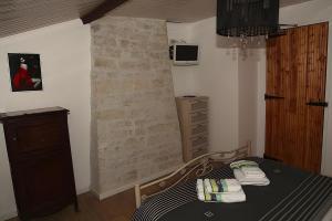 ein Schlafzimmer mit einem Bett, einer Kommode und einer Wand in der Unterkunft Le Bouquet de Soizic in Grandjean