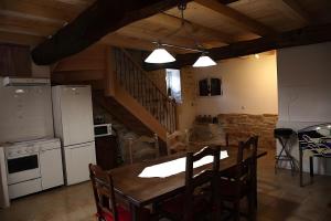 eine Küche und ein Esszimmer mit Tisch und Geräten in der Unterkunft Le Bouquet de Soizic in Grandjean