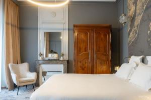 ラ・ロシェルにあるLe Champlainの大きな白いベッドと椅子のある寝室