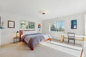 een slaapkamer met een bed en een bureau en twee ramen bij Lakeview Getaway at Rubicon Bay in Rubicon Properties