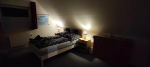a small room with a bed and a night stand at Gemütliches Gästezimmer in Flensburg-Weiche in Flensburg +15 photos