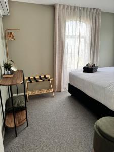 ein Schlafzimmer mit einem Bett und einem Fenster in der Unterkunft The Kings Domain, DUCHESS - Luxurious townhouse in the CBD! in Blenheim