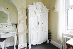 a white cabinet in a room next to a sink at Tower Guest House in York +83 photos