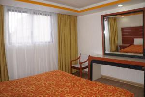 ein Hotelzimmer mit einem Bett und einem Spiegel in der Unterkunft Hotel Puente in Mexiko-Stadt