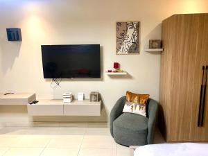 un salon avec une télévision et une chaise dans l'établissement Belrose Place Studio Apartment, à Accra