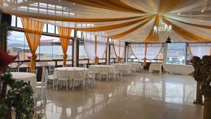 Hotel Cusco Museo في كوسكو: قاعة حفلات بها طاولات وكراسي بيضاء +73 صورة