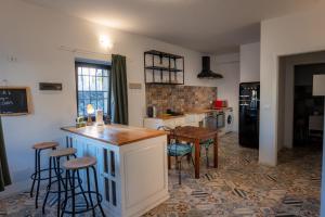 - une cuisine avec un comptoir et quelques tabourets dans l'établissement FIAMBI & b, à Colugna 18 autres photos