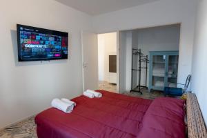 - une chambre avec un lit rouge et une télévision à écran plat dans l'établissement FIAMBI & b, à Colugna