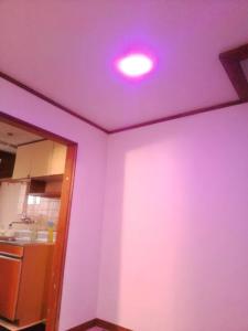 a pink light on the ceiling of a kitchen at ふるさと in Wada